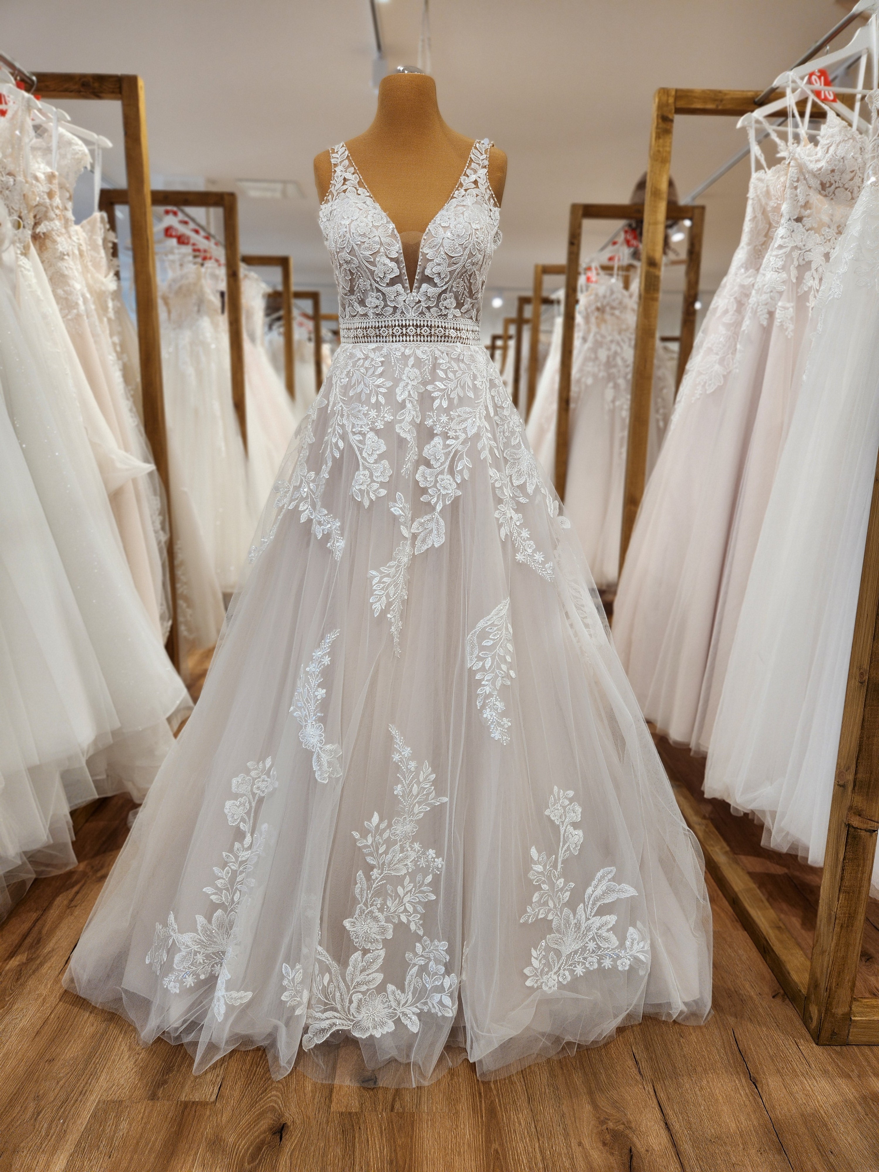 Elegantes A-Linie Brautkleid mit feiner Spitze und tiefem V-Ausschnitt auf einer Schaufensterpuppe bei Susannas Brautmode